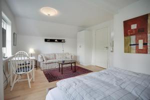 奥尔堡Skovbakkens B&B的白色卧室配有床和沙发