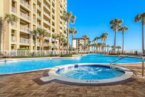巴拿马城海滩Grand Panama Beach Resort #T1-1402的棕榈树建筑前的游泳池