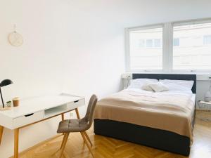 维也纳Ruhige Wohnung im Gasometer Wien *WIFI*U3*Netflix*的一间卧室配有一张床、一张桌子和一把椅子