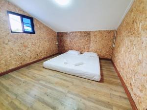 尖竹汶Baan PhakDeeChan的铺有木地板的客房内设有一间卧室和一张床。