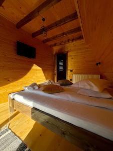 布雷佐伊Hidden Cabin的木制客房内的一张大白色床