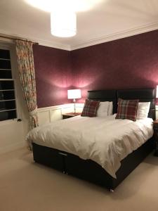 基斯Tullich House的一间卧室配有一张大床和紫色墙壁