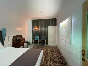 卡拉科尔Duet Hostel & Hotel的酒店客房配有一张床、一张桌子和一把椅子。