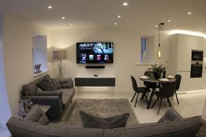 Great UrswickHideaway的客厅配有沙发和墙上的电视