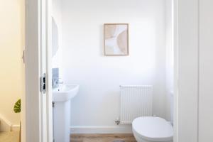 Fortified Three Bedroom Home Bristol的白色的浴室设有卫生间和水槽。