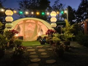 Ban Nong TakhainVilla Noina Glamping的夜间花园内带灯的帐篷