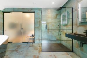 Ashtead维斯特雷旅馆的一间带玻璃淋浴和水槽的浴室