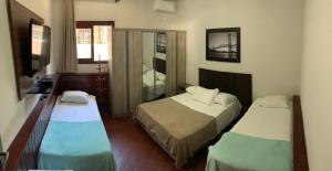 弗洛里亚诺波利斯POUSADA JURERE的酒店客房设有两张床和电视。