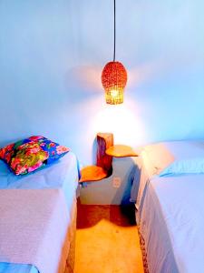 哥隆巴奥Odoyá Corumbau的一间设有两张床、椅子和一盏灯的房间