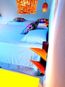 哥隆巴奥Odoyá Corumbau的一间卧室配有两张单人床和色彩缤纷的枕头