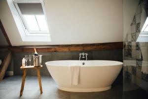 斯蒂夫尼奇红包农舍的浴室配有白色浴缸,设有天窗