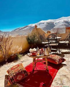 ImilchilChateau Imilchil的沙漠红色地毯上的桌椅