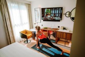 马德里Hard Rock Hotel Madrid的一名在旅馆房间做瑜伽的女士