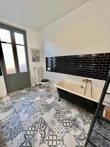 卡尔卡松Carcassonne Bastide的带浴缸的浴室和瓷砖地板。