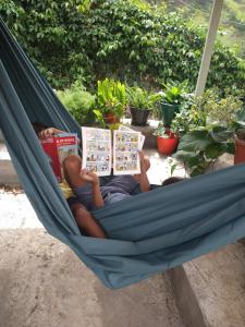 PicosCasa Pé di Polon holiday home的躺在吊床上读书的人