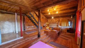 普雷代亚尔Harmonie Tree house Cotagges Chalet Predeal Trei Brazi的小木屋内带楼梯的客厅