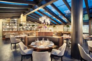苏黎世Hotel UTO KULM car-free hideaway in Zurich的餐厅设有桌椅和玻璃天花板