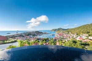 古斯塔维亚Hôtel Barrière Le Carl Gustaf St Barth的享有城市和大海景致的游泳池