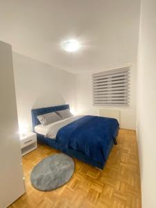 帕莱Apartman Nova Pale的一间卧室配有一张带蓝色毯子的床