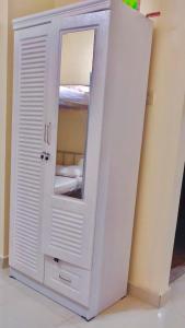 迪拜Welcom Tourist Hostel的客房内的白色橱柜和镜子
