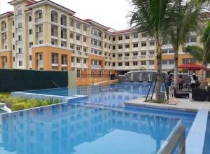 塔里萨伊2BR Casa Mia Sanremo Oasis Cebu的大楼前设有游泳池的酒店