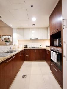 迪拜Spectacular Downtown Apartment T1-34的一个带木制橱柜和水槽的大厨房