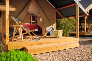 沙尼Camping Du Paquier Fané的帐篷配有一张床和椅子