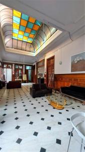 利马1900旅馆的一间设有钢琴和彩色玻璃天花板的大客厅