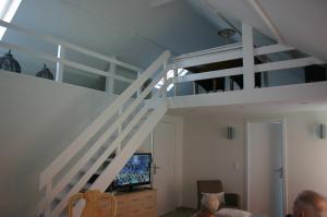 德哈恩"Zee en rust"的客厅配有高架床和电视