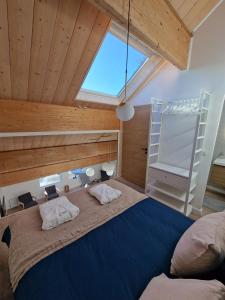 莫尔比耶Duplex type chalet dans le Jura的一间卧室设有一张大床和大窗户