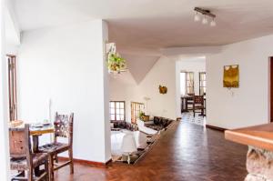维拉卡洛斯帕兹del Buen Ayre的客厅拥有白色的墙壁和桌椅