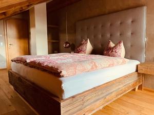 米滕瓦尔德Wally Luxus Lodge im Ferienhaus Magdalena的一间卧室配有一张大床和软垫床头板