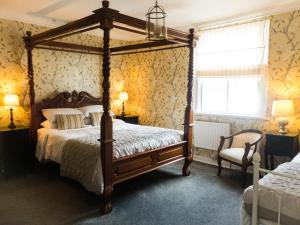 奥尔弗里斯顿叶奥尔德走私者宾馆的一间卧室设有四柱床和窗户。
