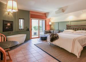 惠提尔Outland Chalet & Suites Great Smoky Mountains的一间卧室设有一张大床和一个浴缸