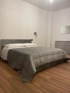 卡萨莱蒙费拉托Prestige Appartament的白色卧室铺有木地板,配有一张大床