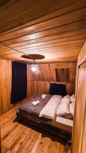 Kʼveda MarghiFeel Funny House的木制客房内的一间卧室,配有一张床