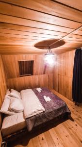 Kʼveda MarghiFeel Funny House的木制客房的一张床位,设有天花板