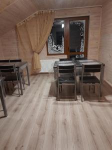 斯拉夫西克Guest House Stari Druzy的一间铺有木地板并配有桌椅的用餐室