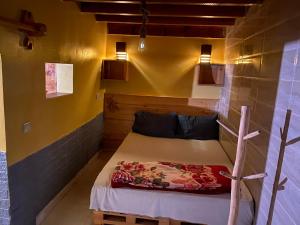 依索安WEST COAST HOSTEL的黄色墙壁的房间里一张小床