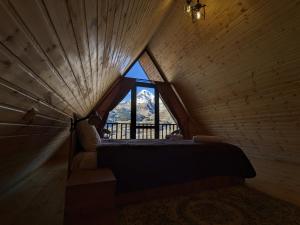 卡兹贝吉Cottage Caucasus的木制客房内设有大窗户的卧室