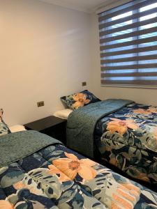 特木科Cabañas y Departamentos Las Palmas, Temuco Depto 4的客房设有两张床和窗户。