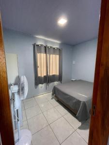 马沙蒂纽Cabanas do Ribeiro的一间卧室配有一张床和一个带风扇的窗户。