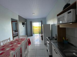 马沙蒂纽Cabanas do Ribeiro的厨房配有桌子、炉灶和冰箱。
