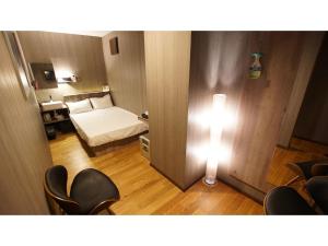 埼玉市hotel mio omiya - Vacation STAY 64001v的小房间,设有一张床,墙上有灯