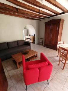 Mareuil-en-BrieCharmant gîte : Les flambeaux的客厅配有红色的沙发和桌子