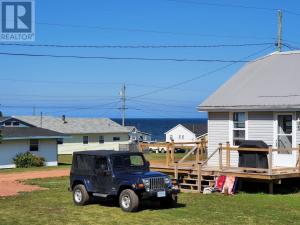 Mount StewartLittle Haven Cottage an ocean view 2 bedroom cottage in Savage Harbour的停在房子前面的蓝色吉普车