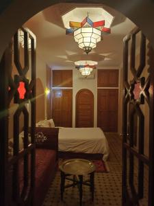 马拉喀什riad rose eternelle的一间卧室配有一张床和一个吊灯