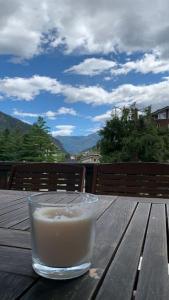 安泰伊-萨伊恩特-安德尔埃Appartamento raccolto con terrazzo e parcheggio的坐在木桌边的一杯牛奶
