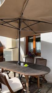 安泰伊-萨伊恩特-安德尔埃Appartamento raccolto con terrazzo e parcheggio的一把伞下的木桌和椅子