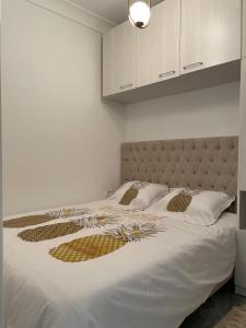 拉马萨LA PETITE PERLE A MARSA PLAGE的一间卧室配有带白色床单和金色枕头的床。